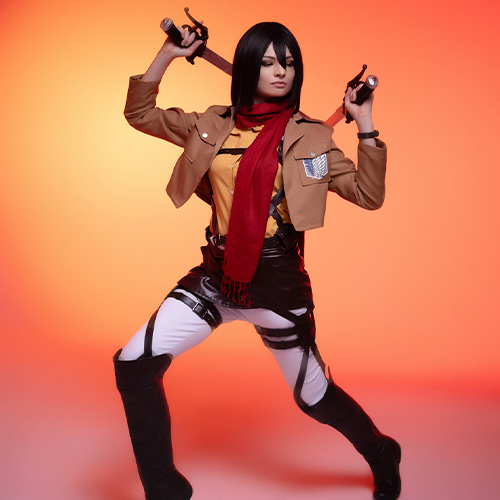 Powerful stance of Mikasa Ackerman from Attack on Titan, holding dual blades in a defensive position, dressed in the Survey Corps uniform, against a fiery orange background