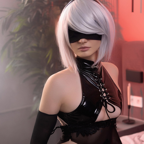 2B from Nier: Automata kneeling on a bed, holding a katana in a seductive black outfit, wearing a blindfold and thigh-high stockings, with soft red and natural light casting a moody ambiance in the room