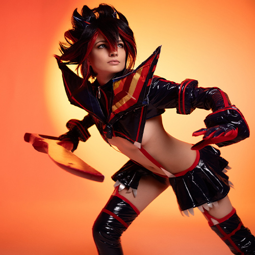 Dynamic Ryuko Matoi cosplay, ready for action with her scissor blade in hand. The character's bold red and black costume contrasts against the vibrant orange background, capturing the intense energy and fierce determination of the Kill la Kill protagonist