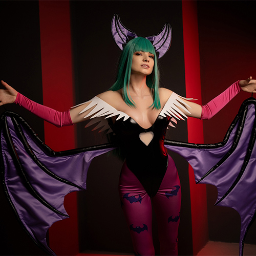 Morrigan Aensland from Darkstalkers strikes an alluring pose, her bat-like wings extended in a dramatic display. The vivid contrast of her green hair and purple winged attire against the dark red and black backdrop brings out her iconic, seductive yet fierce presence. The details in her costume capture the essence of this powerful succubus, showcasing both her elegance and danger in one captivating shot.