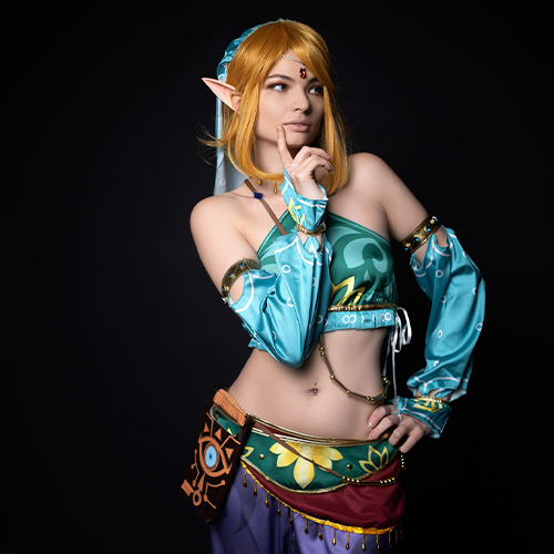 Captivating and sexy Gerudo Link cosplay from The Legend of Zelda: Breath of the Wild, featuring a stunning female version of the beloved character. This gender-bender twist highlights Link’s adventurous spirit with intricate turquoise and gold details, complemented by alluring accessories that add a touch of mystery. The seductive gaze, pointed elf ears, and vibrant Gerudo-inspired attire make this an eye-catching portrayal, embodying a bold, sexy take on the classic hero. Perfect for anyone searching for a fierce and feminine Gerudo Link cosplay or looking to admire a beautiful girl’s take on this iconic outfit