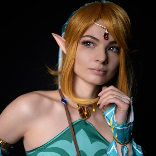 A mesmerizing close-up of a sexy, gender-bent Link in Gerudo attire, bringing a sensual twist to this iconic character from The Legend of Zelda: Breath of the Wild. The cosplayer’s alluring expression, detailed elf ears, and elegant accessories create a captivating portrayal of a female version of Link. With vibrant turquoise and gold accents, this cosplay captures both strength and femininity, perfect for fans seeking a bold, seductive interpretation of the hero. A must-see for those interested in unique, sexy takes on classic game characters.