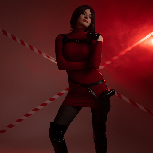 Bold Ada Wong cosplay inspired by the iconic Resident Evil series, featuring the character's signature red mini-dress paired with black tactical accents and thigh-high boots. This powerful pose highlights Ada’s confident and enigmatic persona, with attention to her sleek bob hairstyle and mysterious allure. The combination of dramatic lighting and vivid costume details creates an intense atmosphere, perfectly capturing the essence of this legendary character.