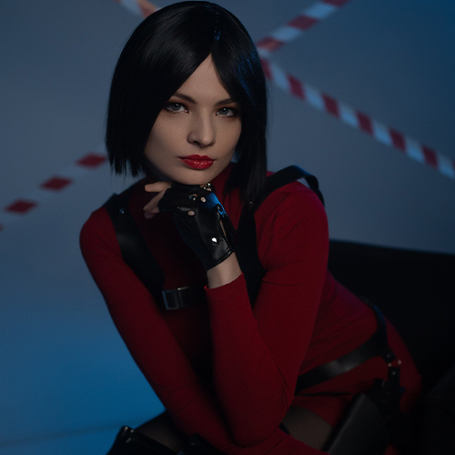 Ada Wong cosplay from Resident Evil, exuding an air of mystery and confidence. The sleek bob haircut frames a piercing gaze, while the red dress and tactical black gloves emphasize her femme fatale essence. Posed against a dimly lit backdrop with caution tape, the composition captures Ada's calculated and enigmatic nature. This stunning representation highlights the elegance and danger associated with one of Resident Evil’s most iconic characters.