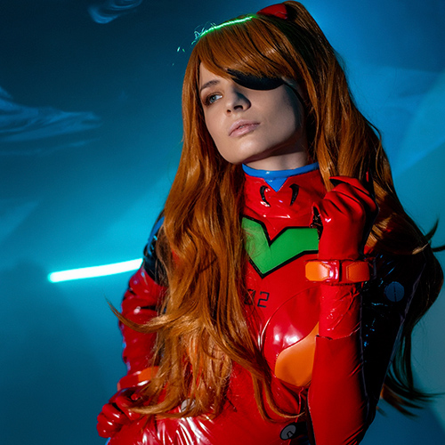 Asuka Langley Soryu cosplay from Neon Genesis Evangelion, capturing her fiery and bold personality with incredible detail. Dressed in the iconic red plugsuit, complete with the green and orange accents that define her character, this portrayal emphasizes Asuka's confident and strong-willed nature. The striking orange wig and eye patch add depth, reflecting her storyline from the Rebuild series. The dramatic lighting and futuristic background evoke the intense world of Evangelion, making this a stunning tribute to one of anime's most iconic pilots.