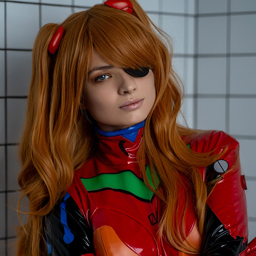 Asuka Langley Soryu cosplay from Neon Genesis Evangelion, featuring a perfect recreation of her signature red plugsuit with vibrant green and orange accents. The twin tails hairstyle and eye patch reflect her iconic look, adding authenticity and character depth. Set against a clean, tiled background, this portrayal emphasizes Asuka's bold and determined personality while highlighting the sleek design of the Evangelion universe. A stunning representation of one of anime's most celebrated characters.