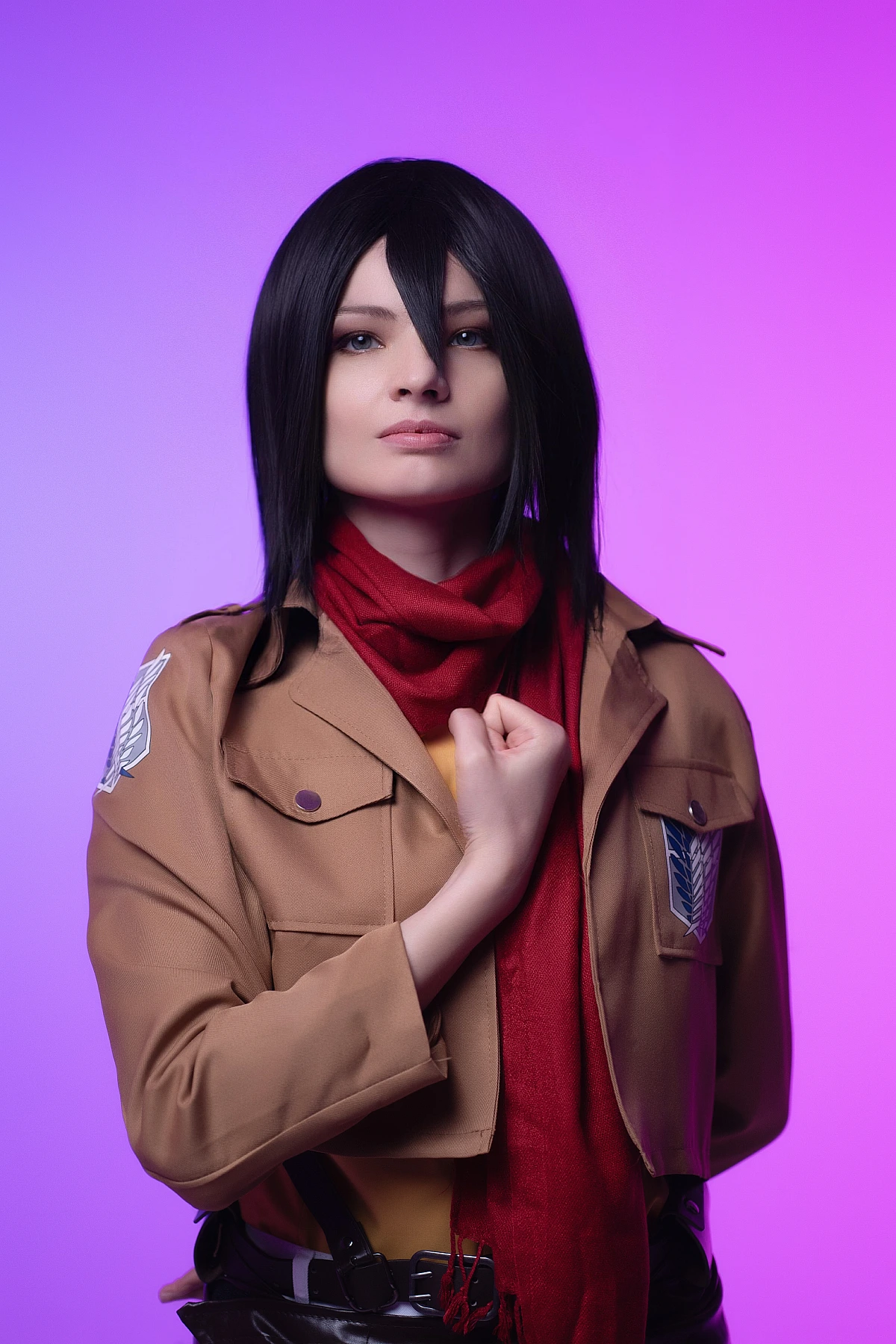 mikasa ackerman cosplay portrait close-up with red scarf and survey corps jacket against purple studio backdrop