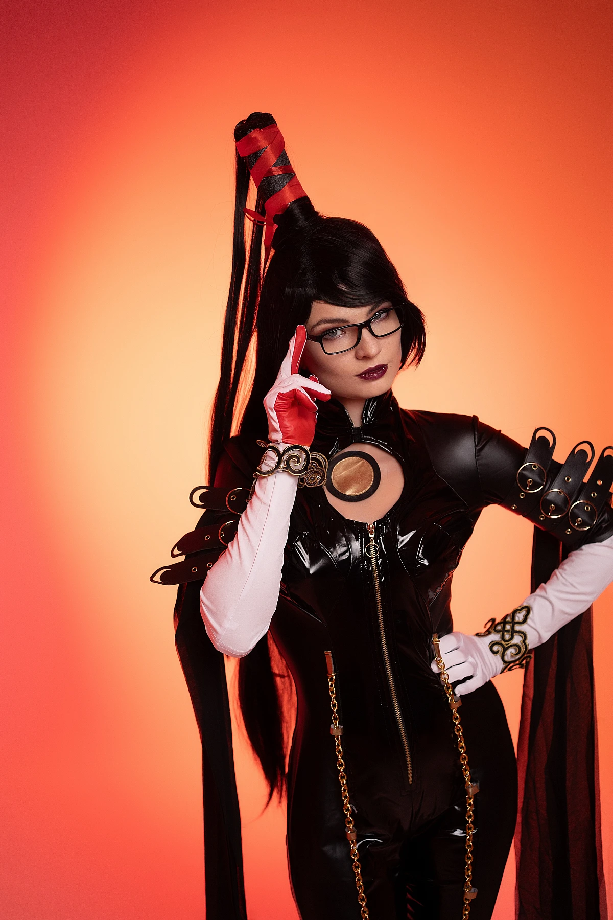 Bayonetta cosplay close-up portrait with glasses and deliberate hand gesture, glossy black bodysuit, warm orange lighting by Neka-Chi