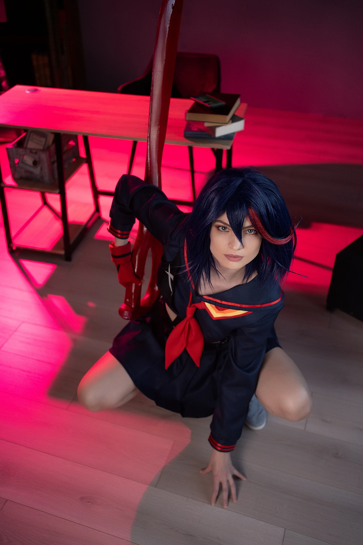 Ryuko Matoi cosplay crouching from top-down angle with crimson blade in red neon light
