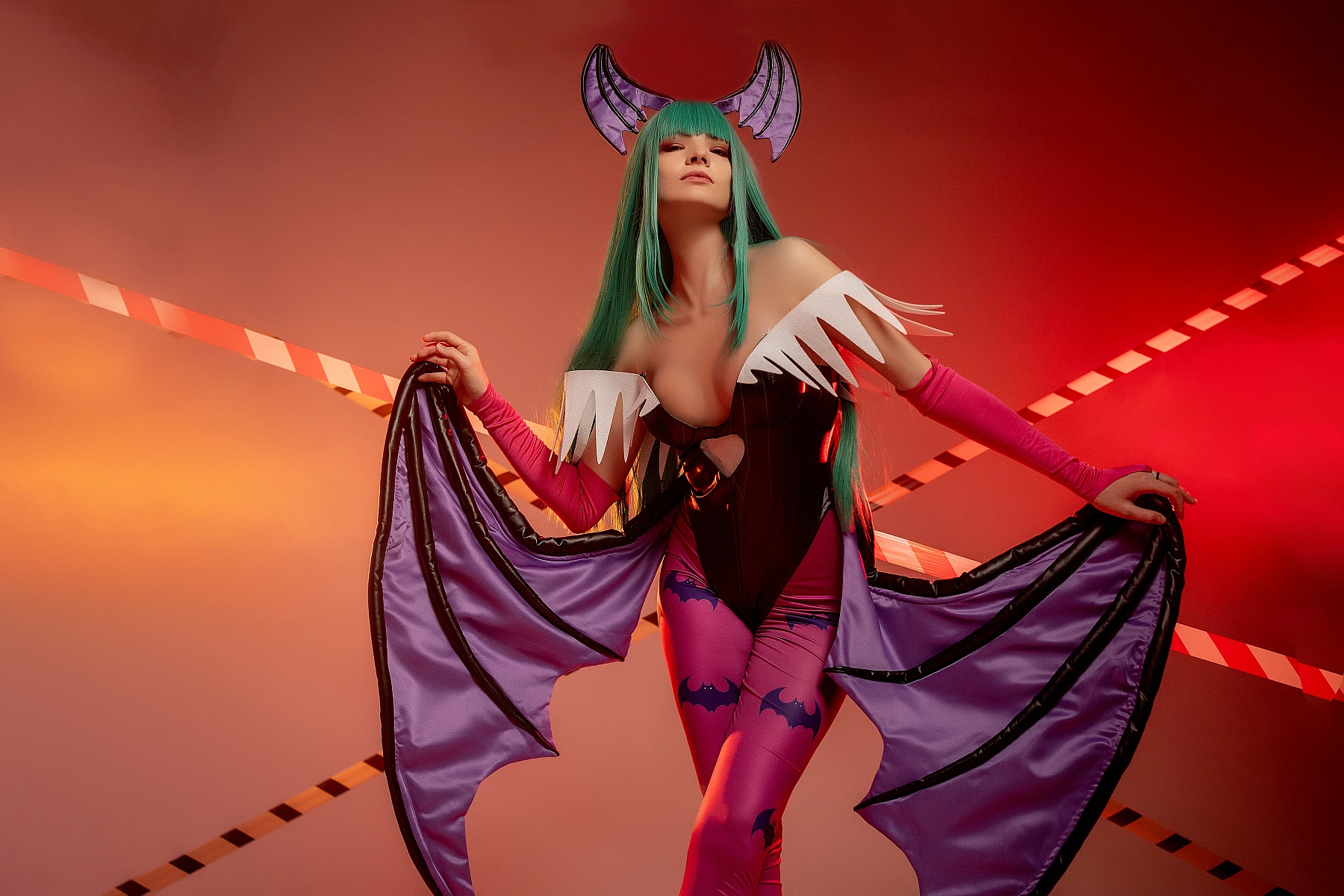 Morrigan Aensland cosplay full wing spread, symmetrical pose, warm orange-red studio lighting, glossy bodysuit, green hair