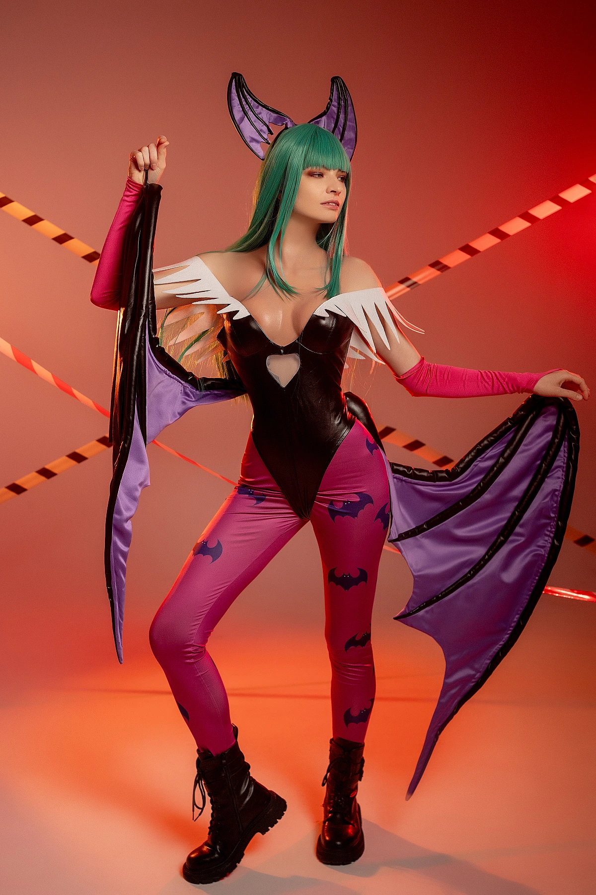 Morrigan Aensland cosplay with asymmetric wings, warm orange-red studio lighting, sideways angle, glossy bodysuit