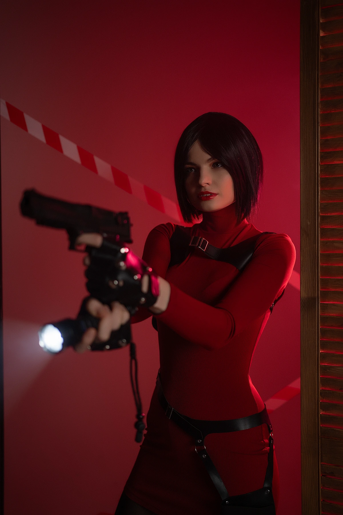 Ada Wong cosplay close-up handgun flashlight beam red neon lighting leather harness straps bob haircut