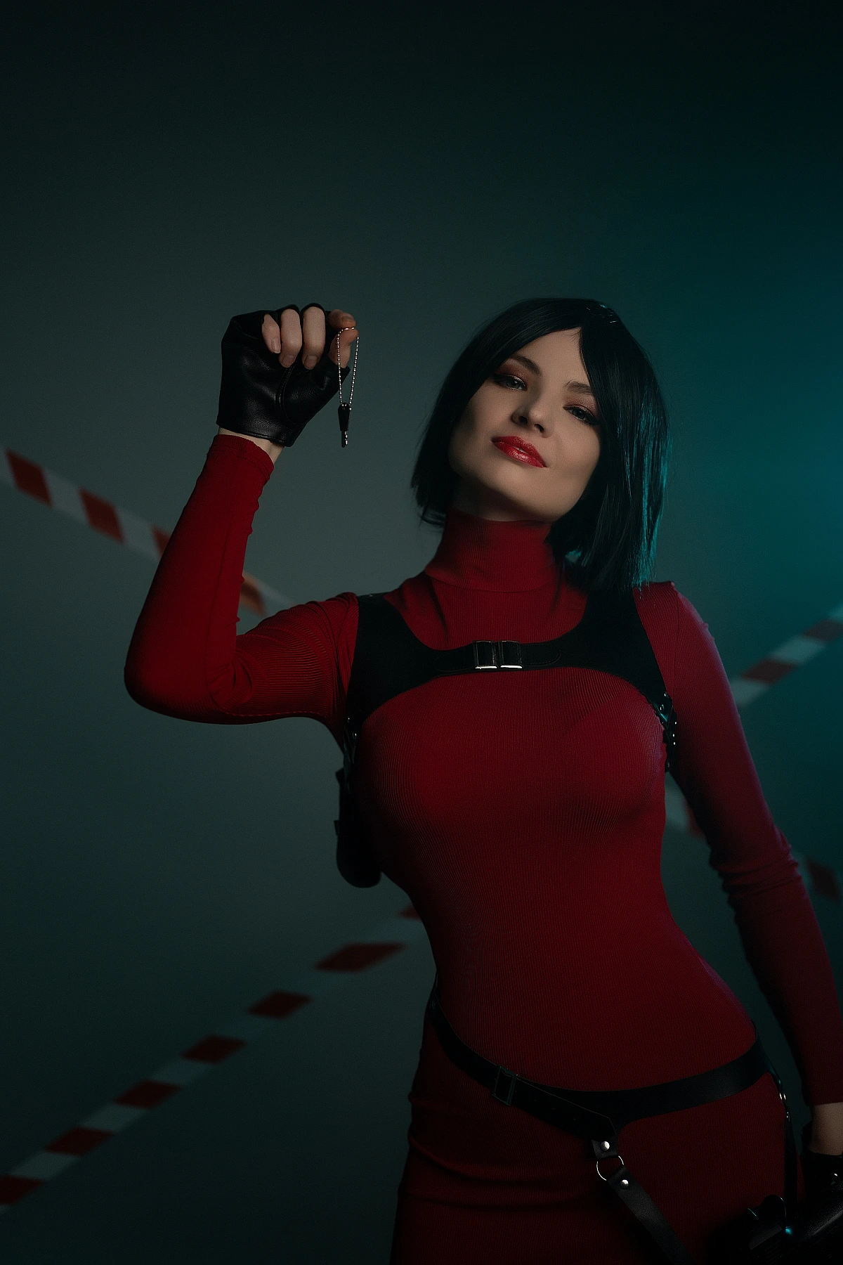 Ada Wong cosplay portrait spy accessory raised hand red outfit black gloves cool blue studio light