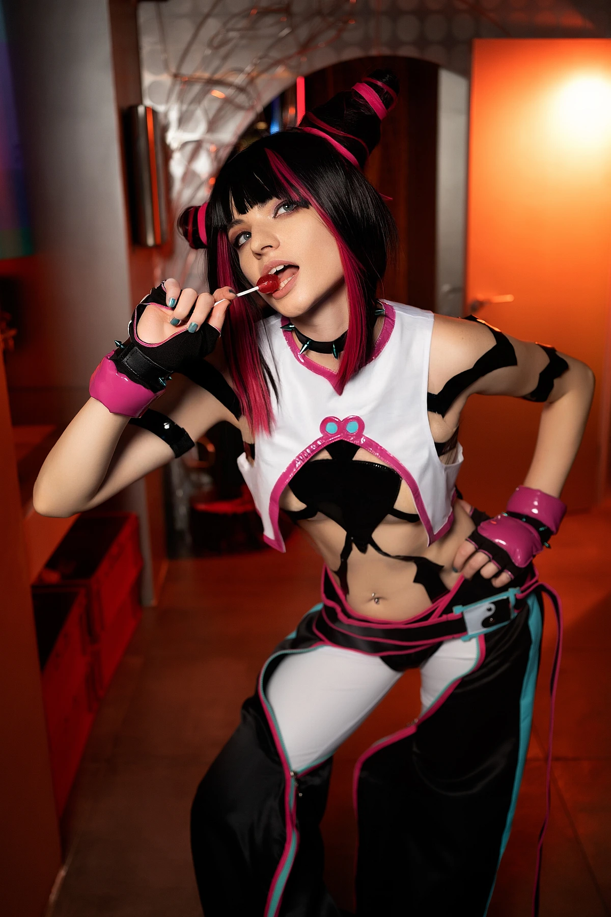 Juri Han cosplay close-up with lollipop, playful teasing expression, warm orange neon lighting highlighting face and hair