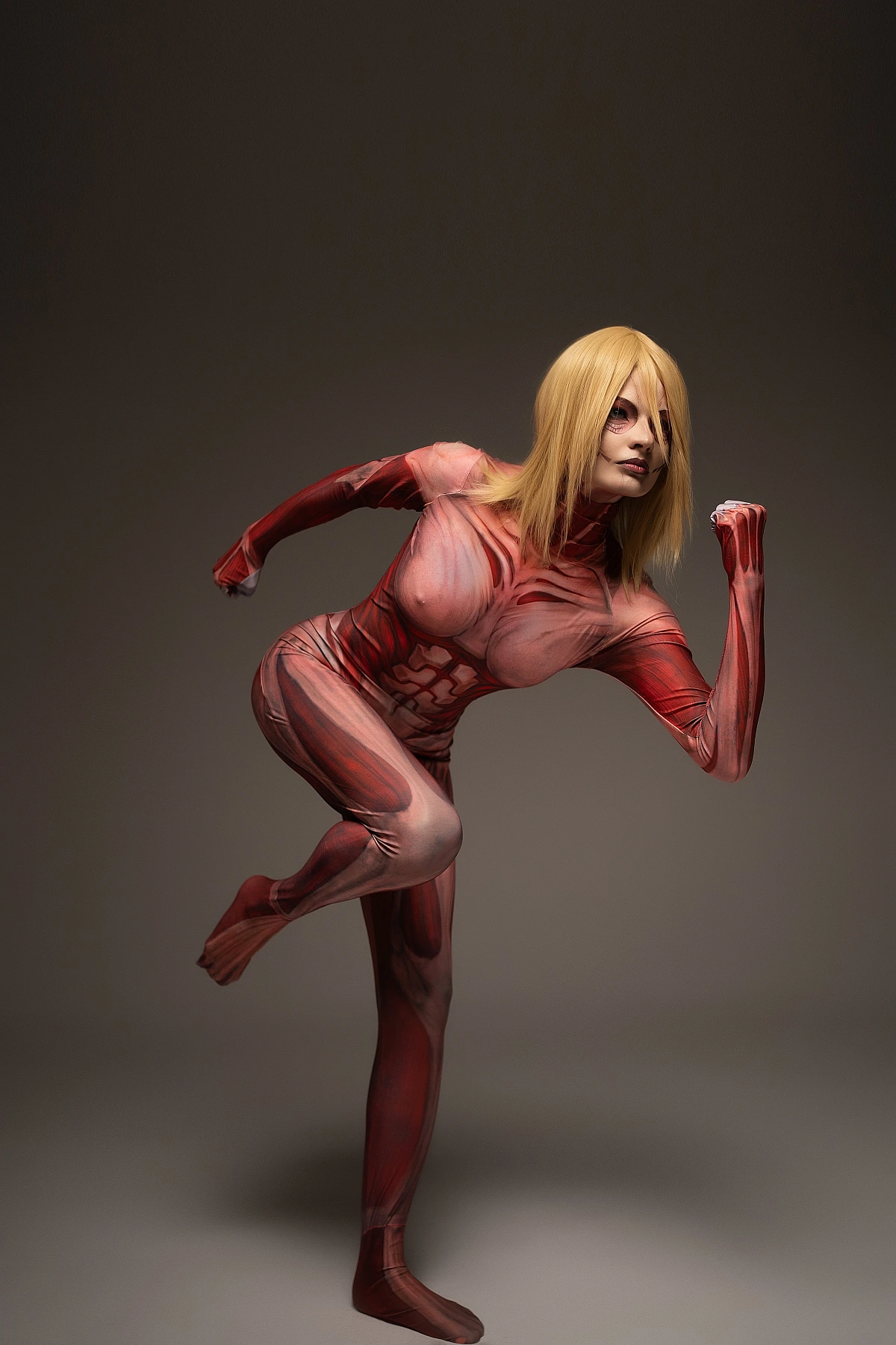 Female Titan cosplay running mid-stride, Annie Leonhart sprint pose, anatomical muscle bodysuit, AOT action cosplay