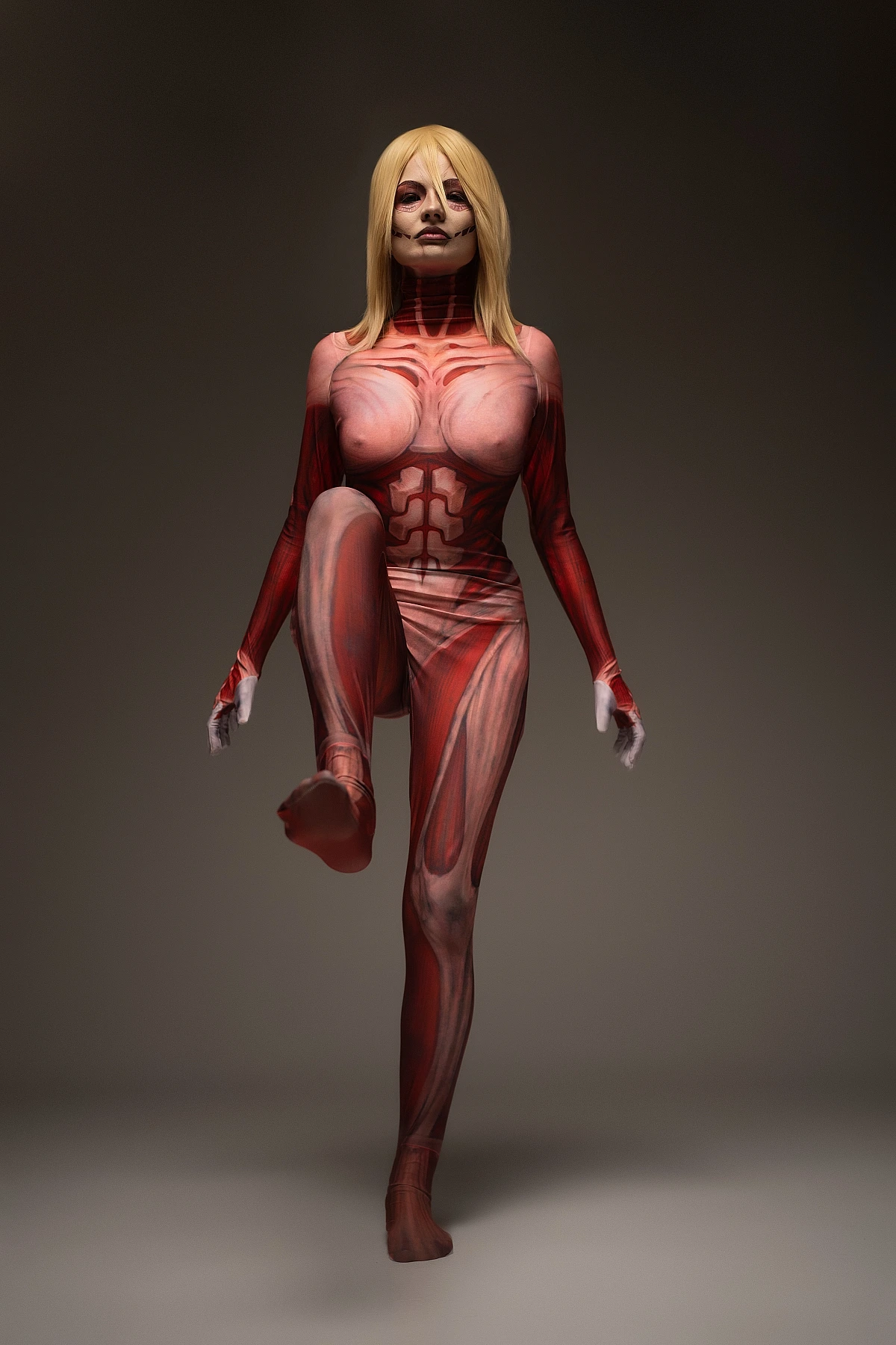 Female Titan cosplay barefoot pose, Annie Leonhart raised leg, anatomical muscle bodysuit, balance stance AOT cosplay