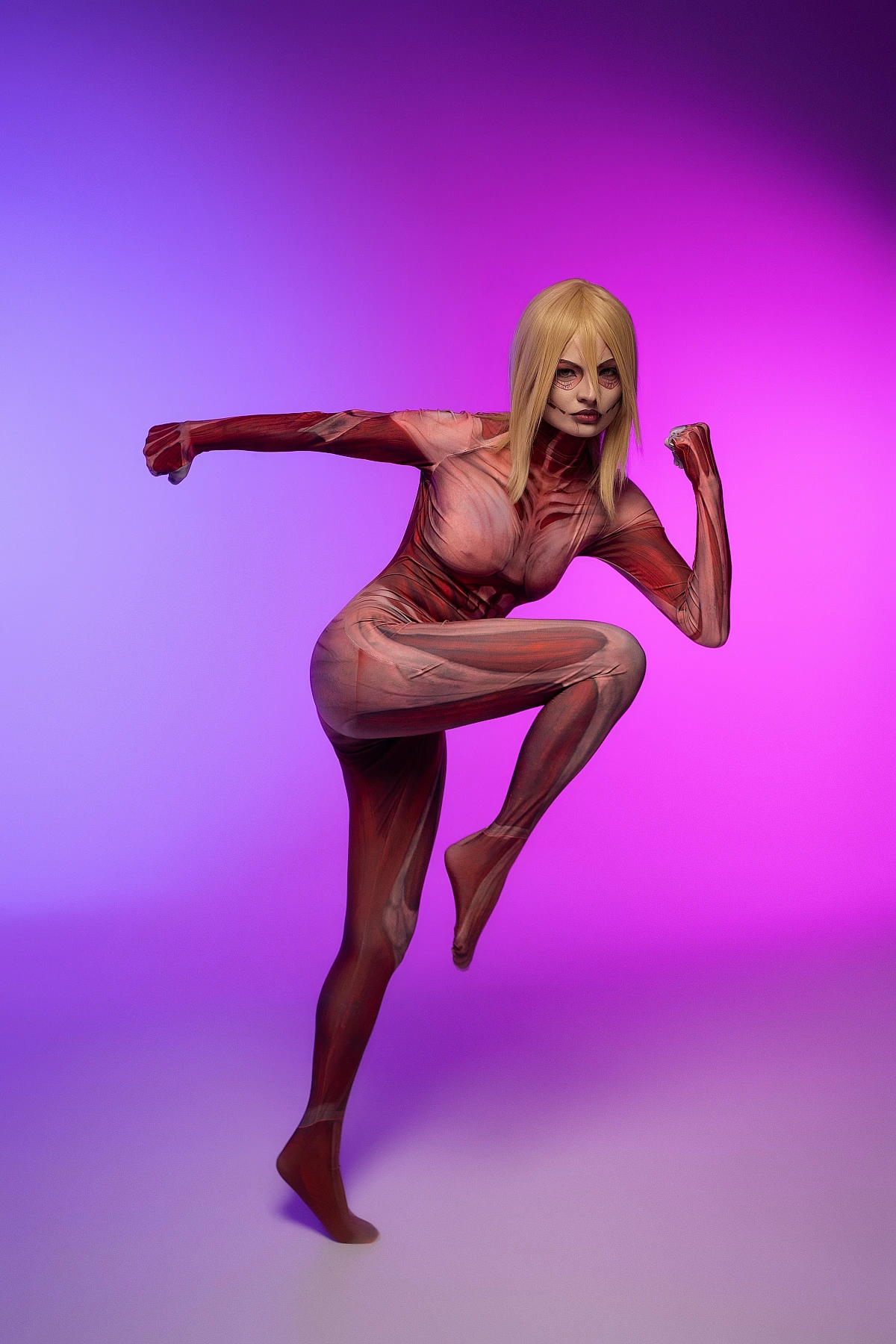 Female Titan cosplay jump kick mid-air, Annie Leonhart, anatomical muscle bodysuit, purple pink gradient AOT cosplay