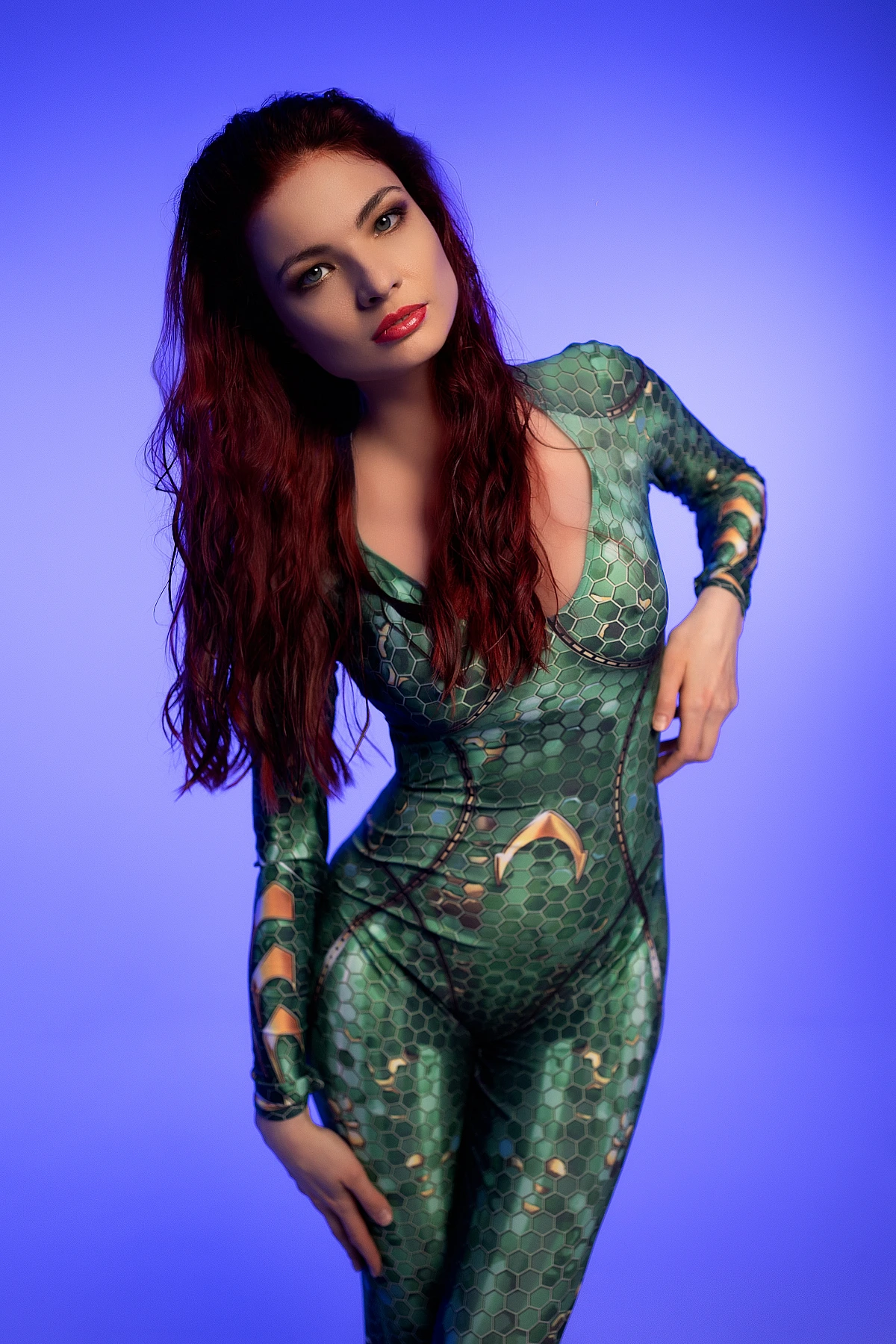 Leaning forward Mera cosplay portrait with direct gaze wearing emerald scale bodysuit