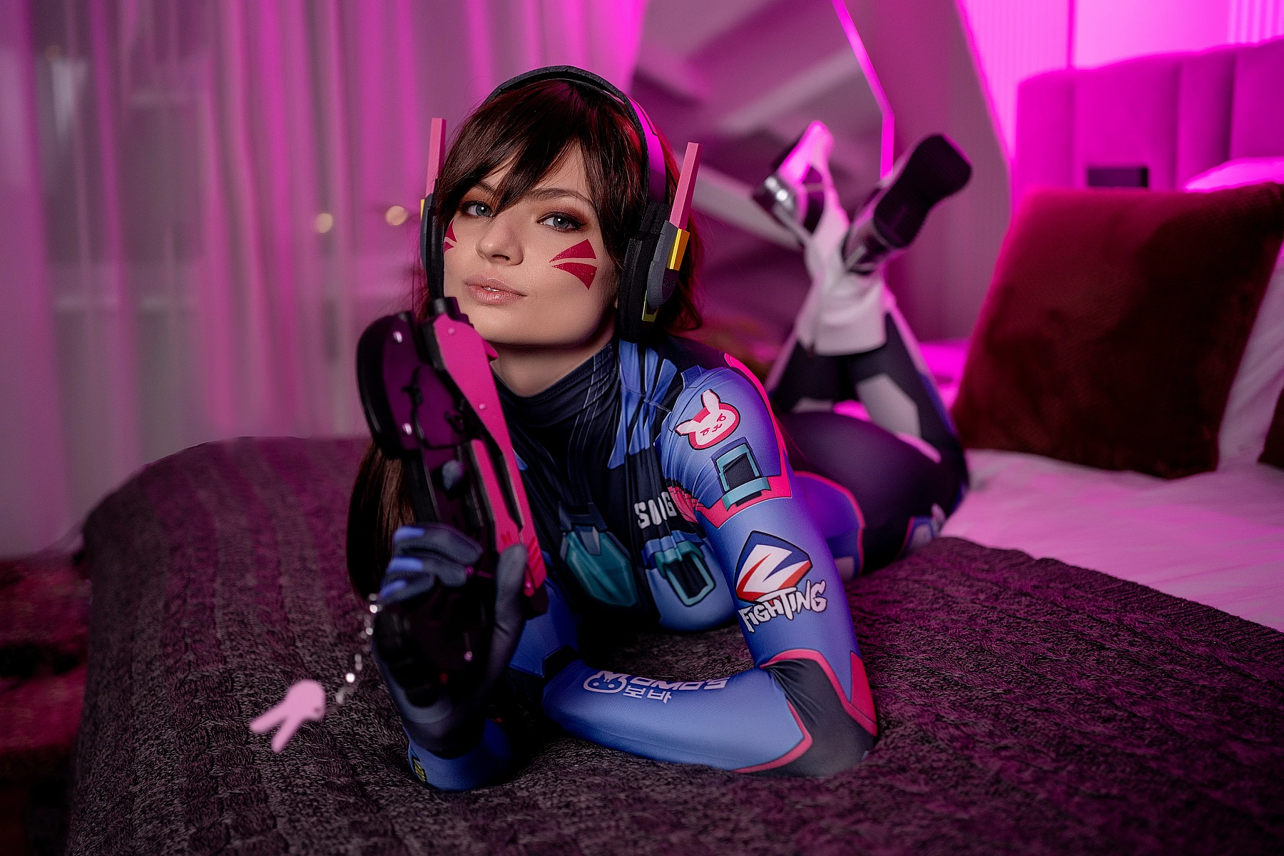 D.Va cosplay intimate portrait, soft pink neon glow, light gun prop, direct gaze, glossy bodysuit sheen, Overwatch fan photography