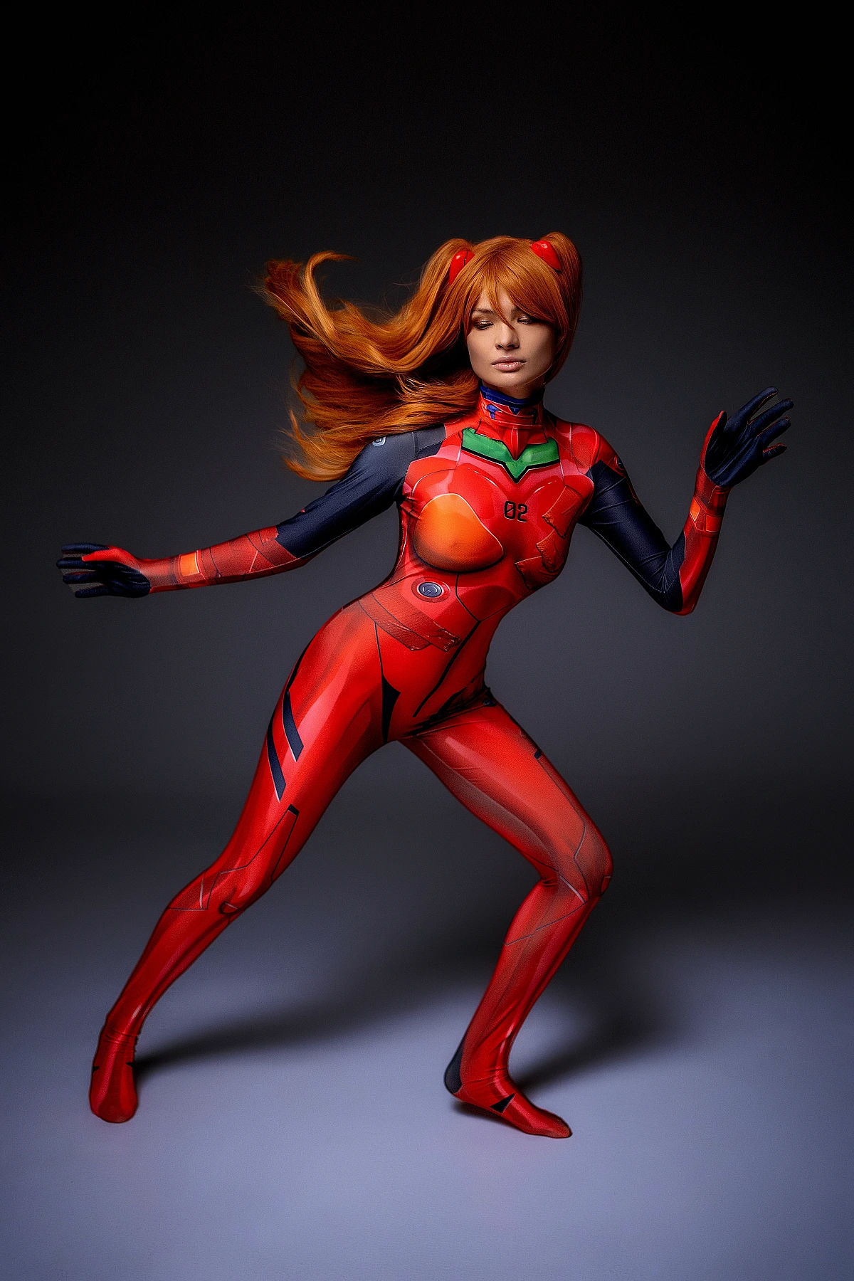 Asuka Langley cosplay mid-motion in red plugsuit with flowing hair and raised arms