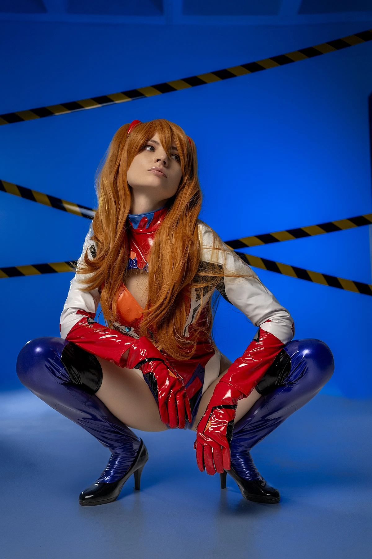 Asuka EVA plugsuit deep squat cosplay on blue background with red gloves