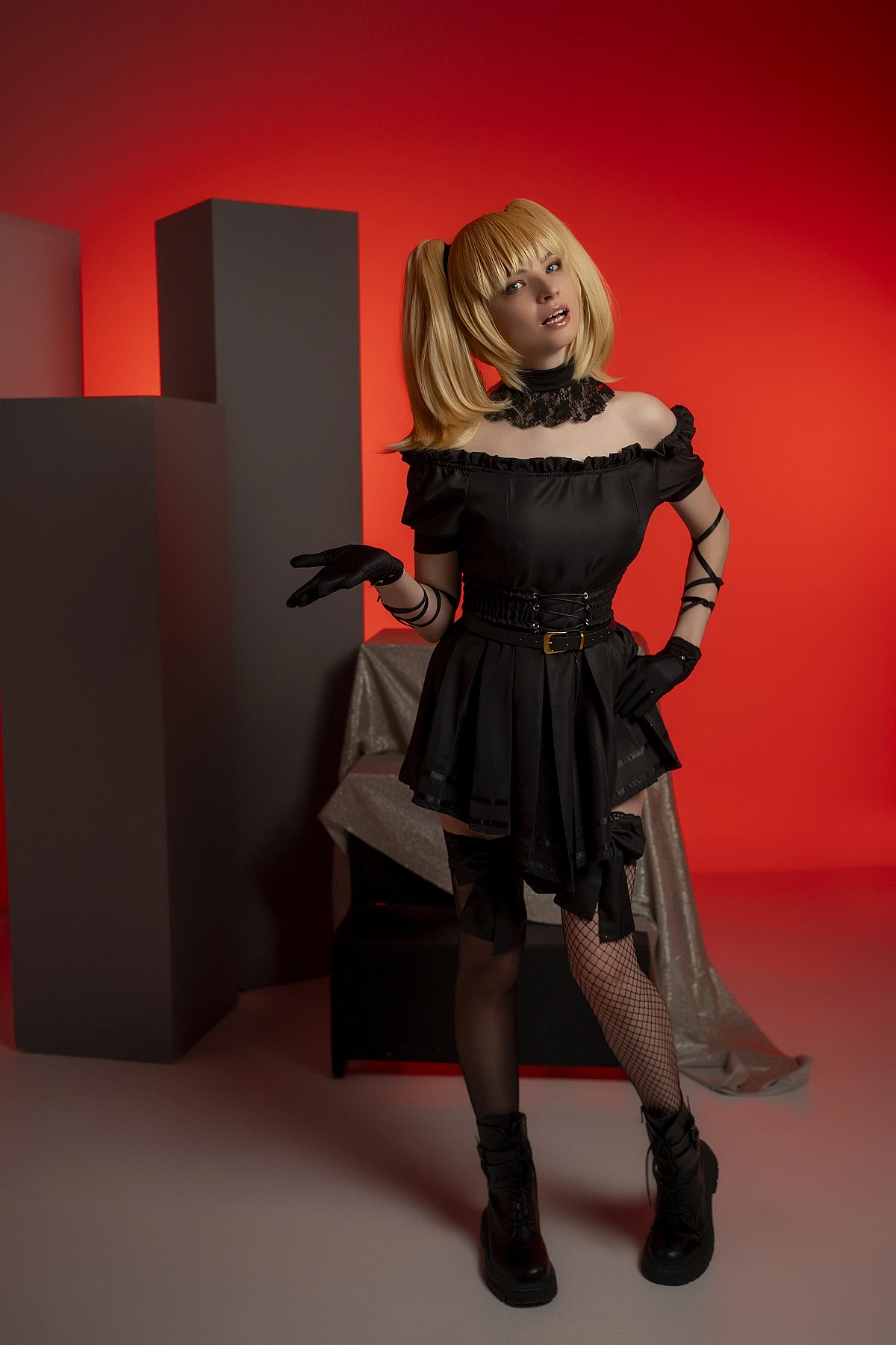 Ani cosplay model standing pose, black dress, red backdrop, twin tail hair, lace gloves, anime style