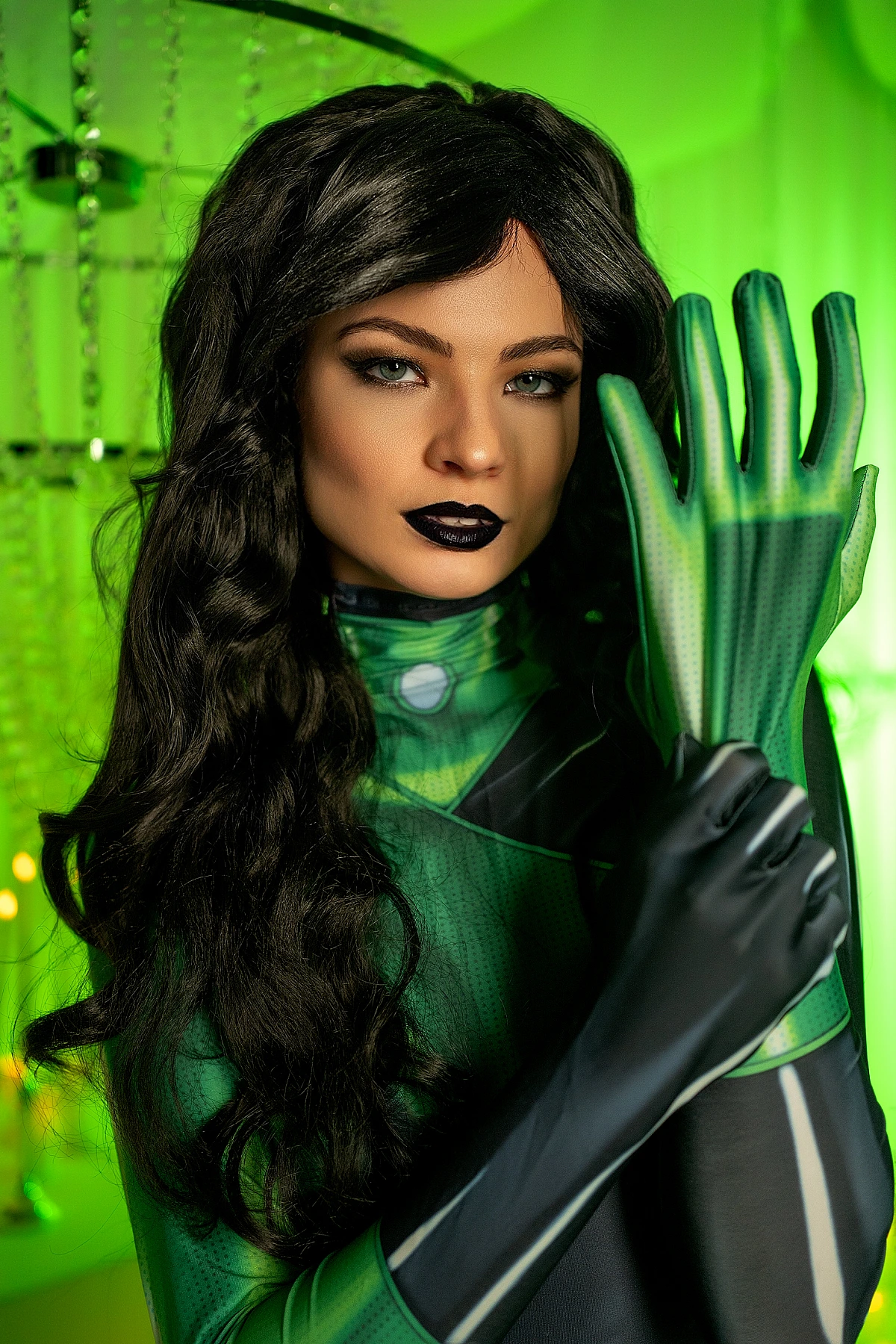 Shego cosplay close portrait, raised green glove, focused gaze, emerald background