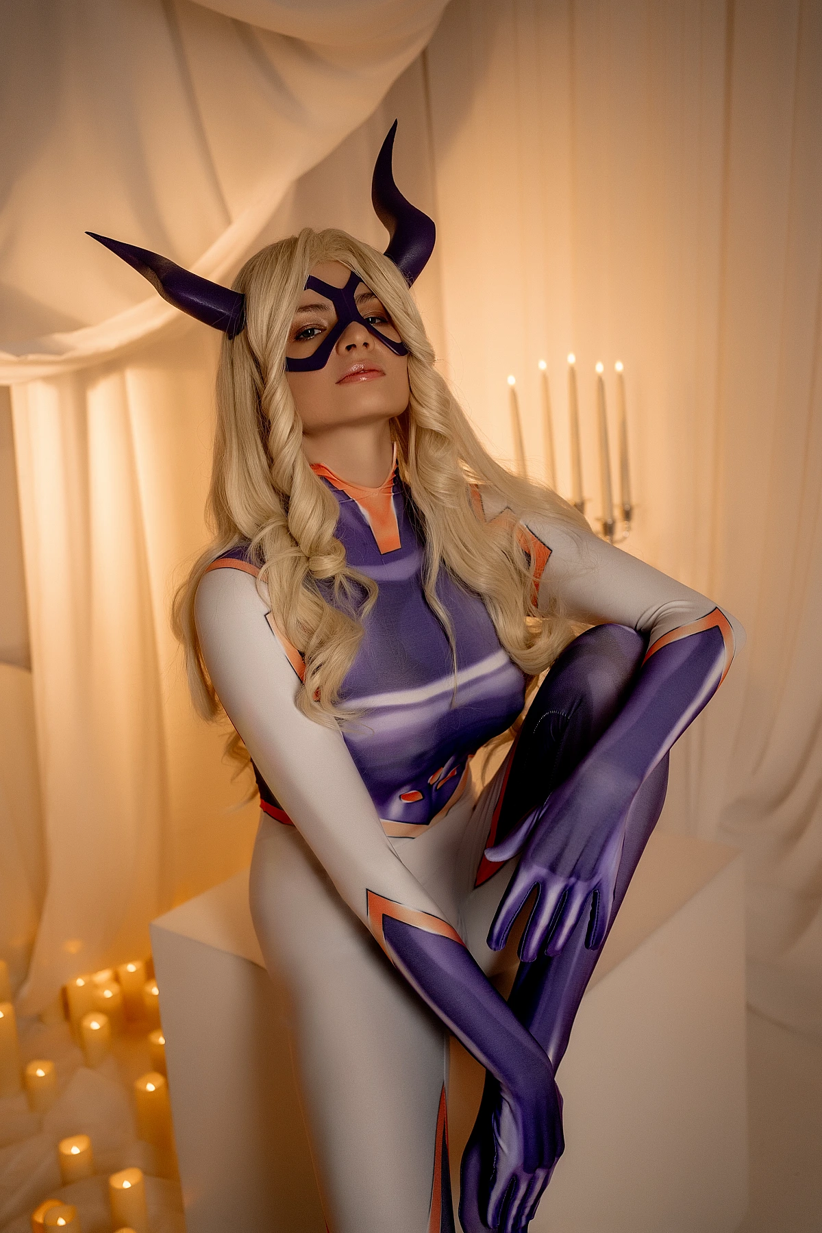 Mt. Lady cosplay confident heroine stance in tight bodysuit with horned mask under clean studio light