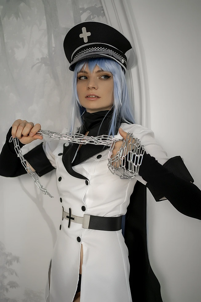 Esdeath cosplay from Akame ga Kill! standing by a wall and pulling a heavy silver chain taut in front of her chest