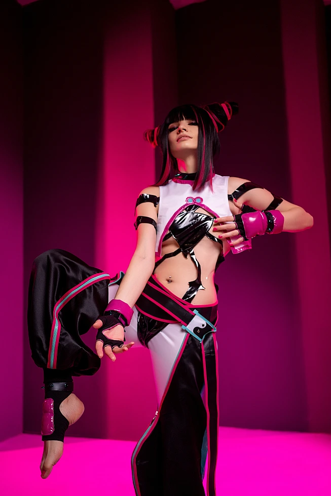 Juri Han cosplayer balancing on one leg with raised knee, violet neon studio lighting, glossy black costume, horn buns, Street Fighter