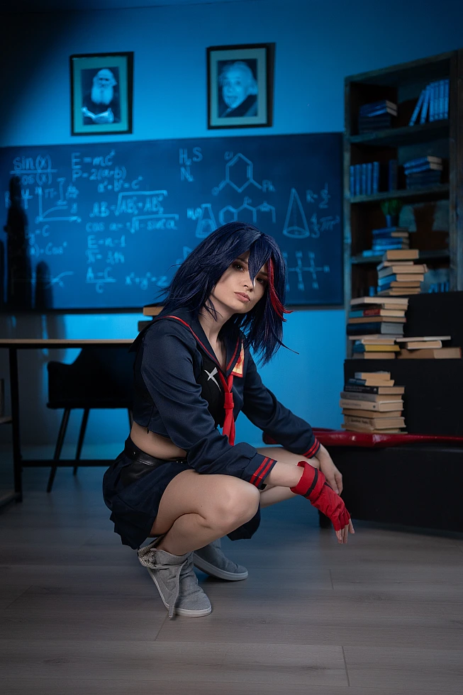 Ryuko Matoi cosplay crouching in blue-lit classroom with chalkboard equations