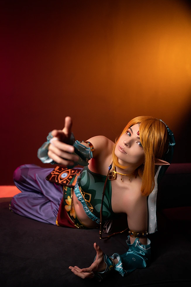 Gerudo Link cosplay reclining with amber lighting and forward gesture
