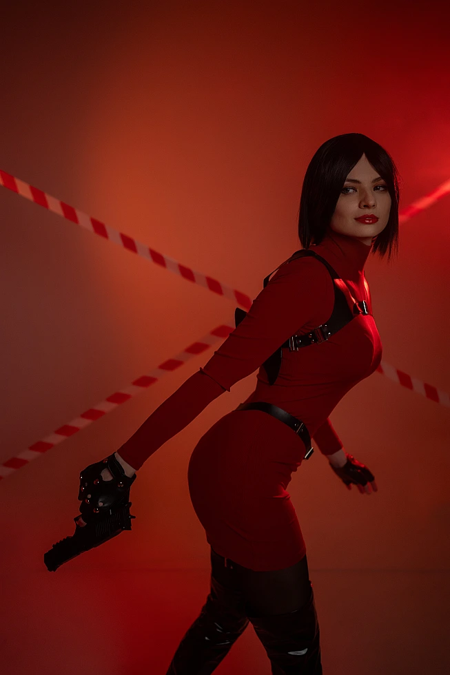 Ada Wong cosplay side profile mid motion red outfit harness pistol held low warm red glow