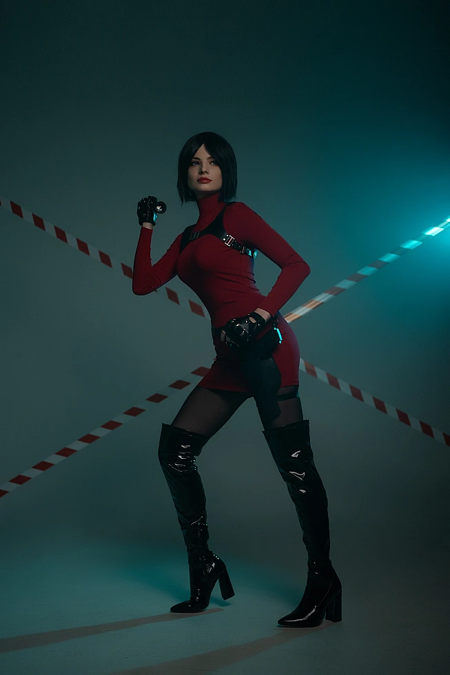 Ada Wong cosplay full body stance red dress thigh-high heeled boots raised arm pose blue studio light