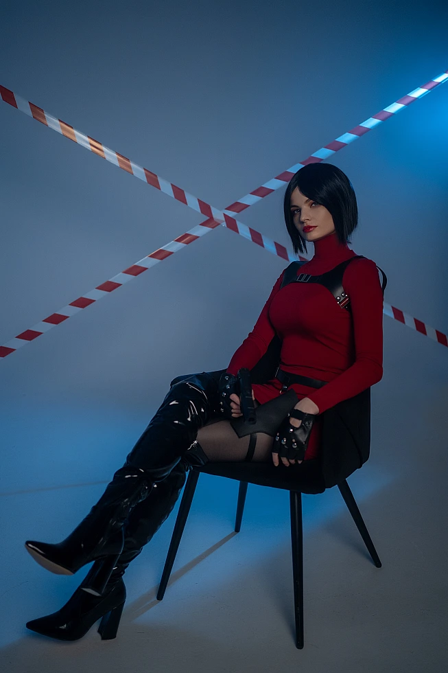 Ada Wong cosplay seated chair crossed legs red dress thigh-high boots pistol blue light diagonal tape