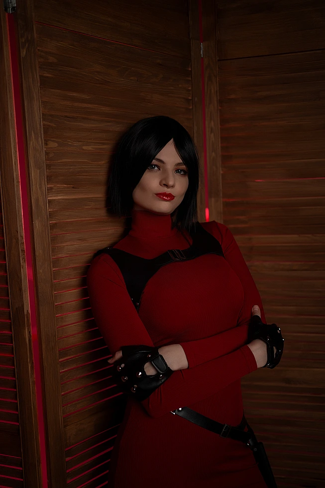 Ada Wong cosplay portrait wooden panels red outfit crossed arms black gloves warm red glow elegant