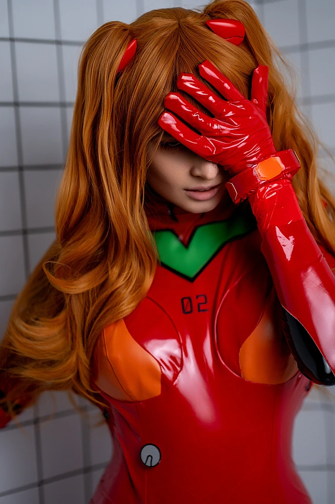 Detailed close-up of Asuka Langley red plugsuit cosplay showing glossy wetlook texture, seam lines and eyepatch under controlled studio lighting