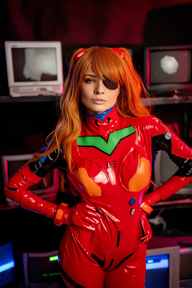 Asuka Langley plugsuit cosplay portrait with eyepatch, surrounded by glowing CRT monitors in dark cyberpunk studio with neon green and orange lighting