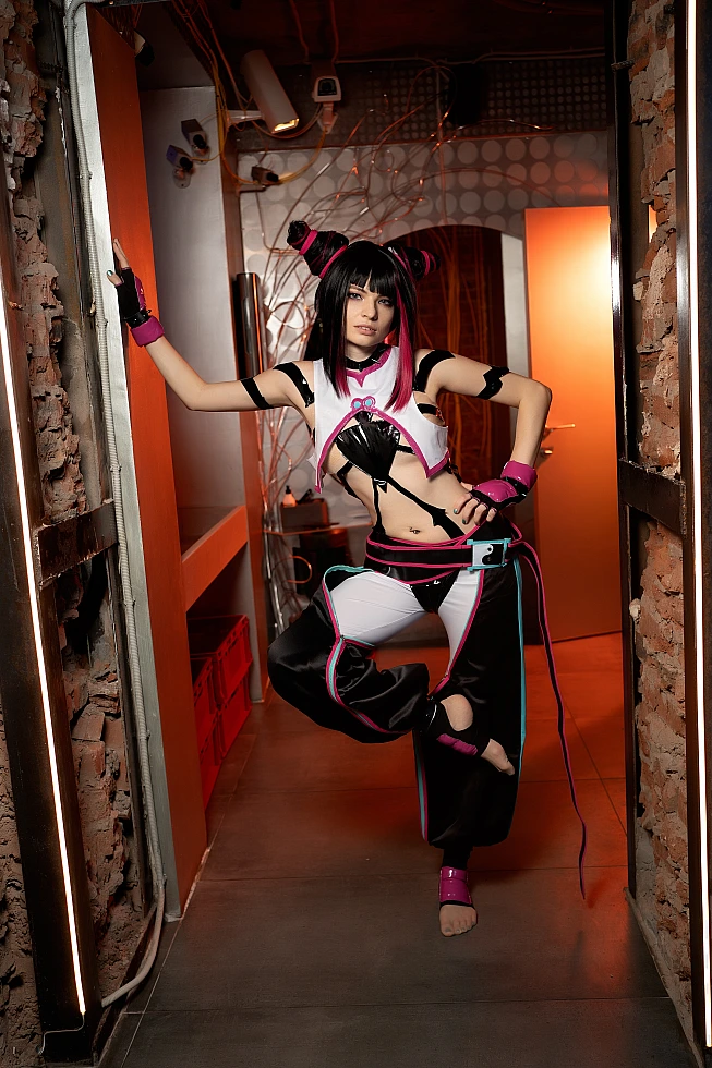 Juri Han cosplay one-leg balance pose in neon doorway, orange industrial lighting, demonstrating fighting game kick stance