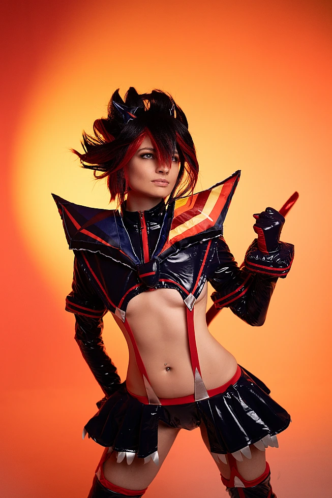 Ryuko Matoi cosplay close-up portrait with intense expression warm orange studio lighting detailed Senketsu costume Kill la Kill