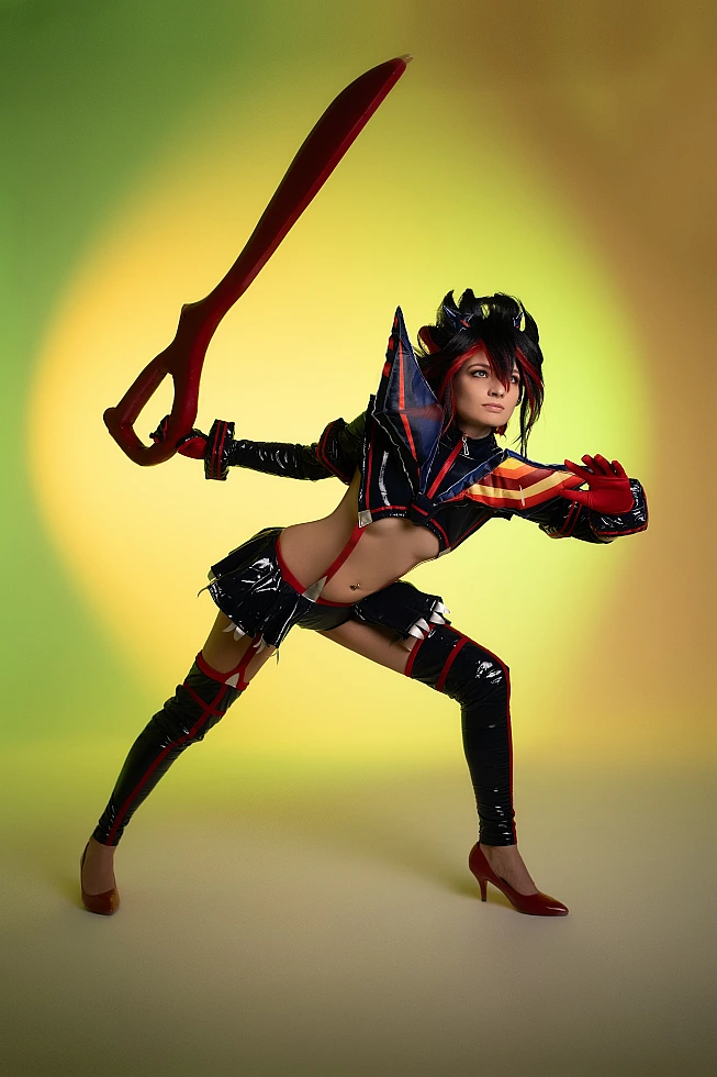 Ryuko Matoi cosplay in wide combat action stance with scissor blade neon green yellow studio background Kill la Kill anime