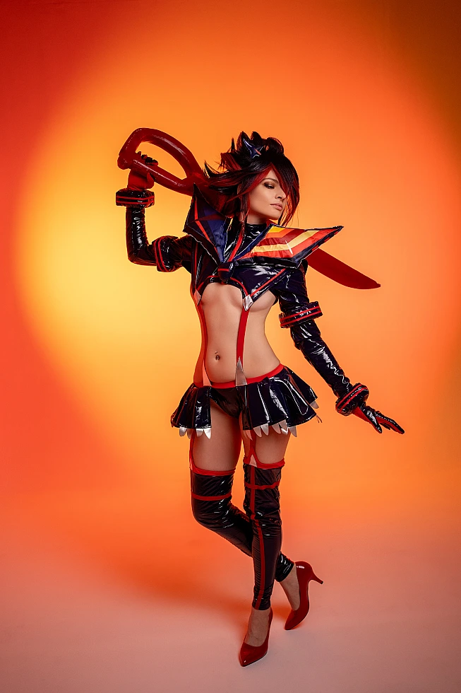 Ryuko Matoi cosplay side profile view scissor blade over shoulder orange neon studio background wetlook glossy outfit Kill la Kill