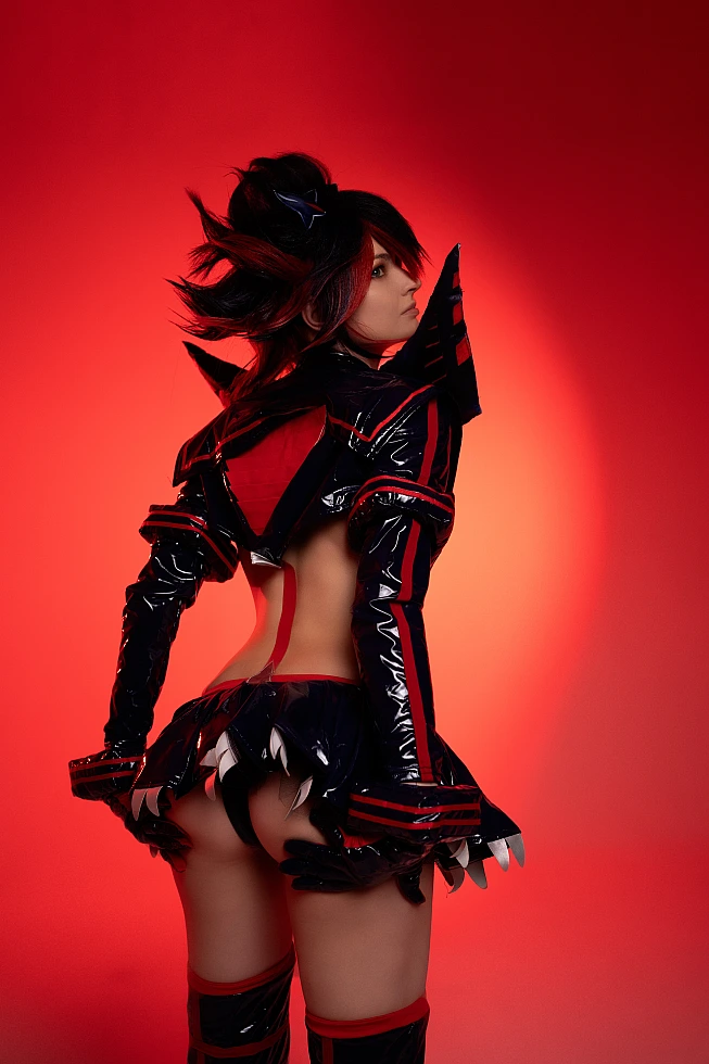 Thicc anime girl Ryuko Matoi cosplay back profile, sexy bootty and ass tease with wet latex skirt lift, stockings, gloves on vibrant red gradient backdrop.