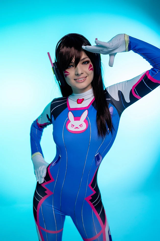D.Va Overwatch cosplay portrait salute gesture cyan neon lighting headset face markings character study