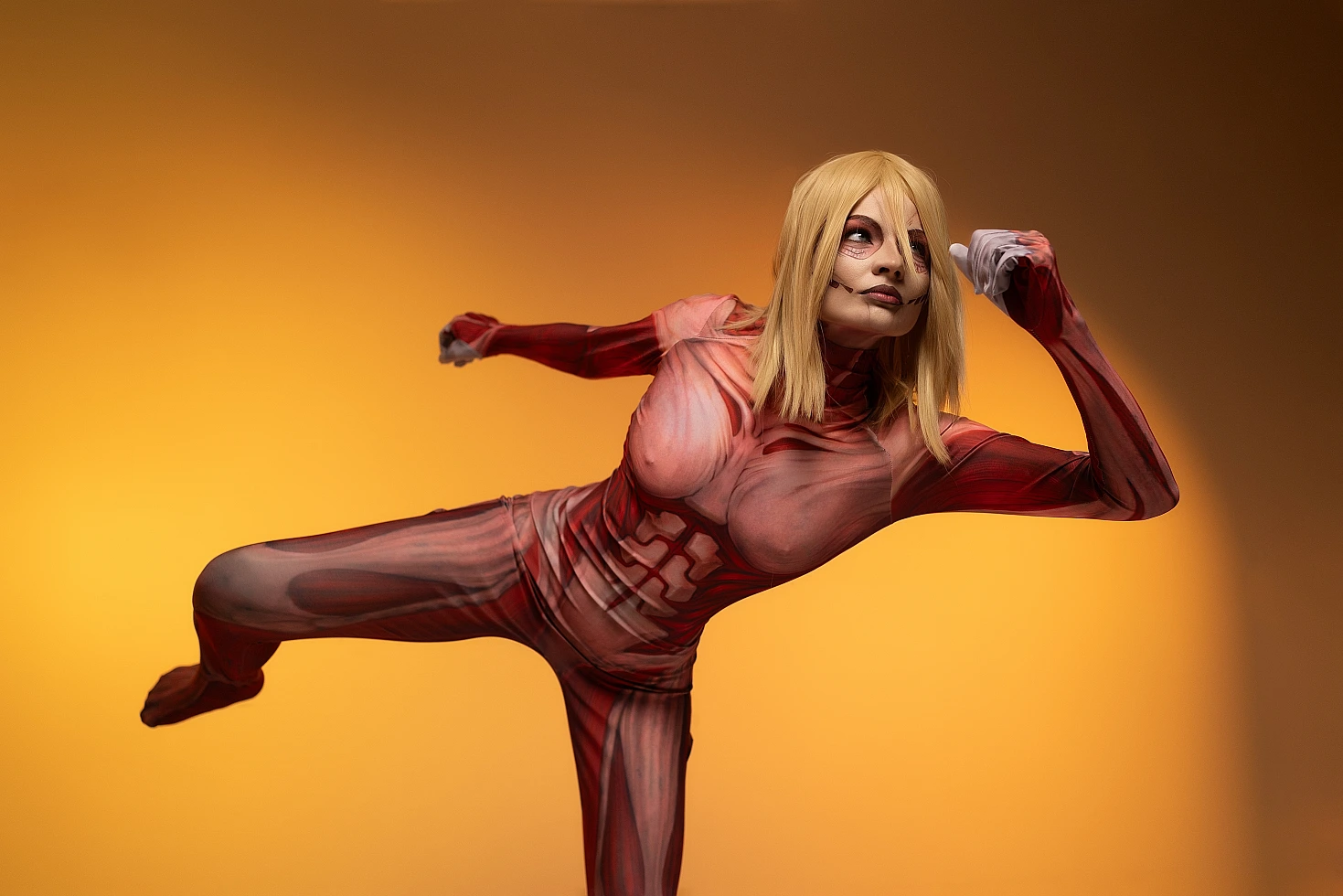 Female Titan cosplay side kick action, Annie Leonhart diagonal pose, anatomical muscle bodysuit, orange background AOT cosplay