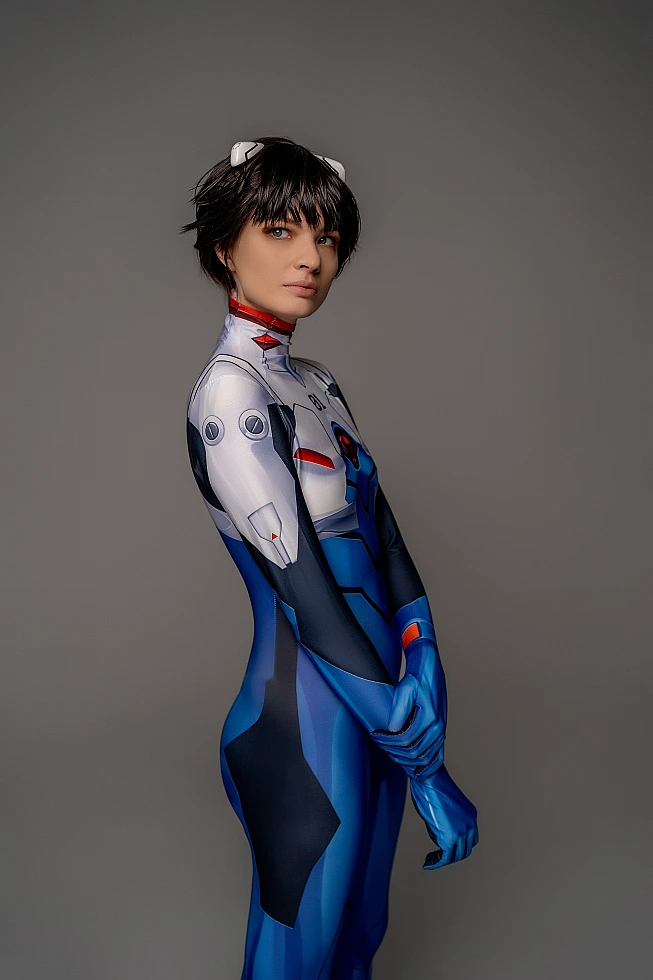 androgynous Shinji Ikari cosplay side profile, fitted blue bodysuit, slim silhouette, anime crossplay photography, gray studio