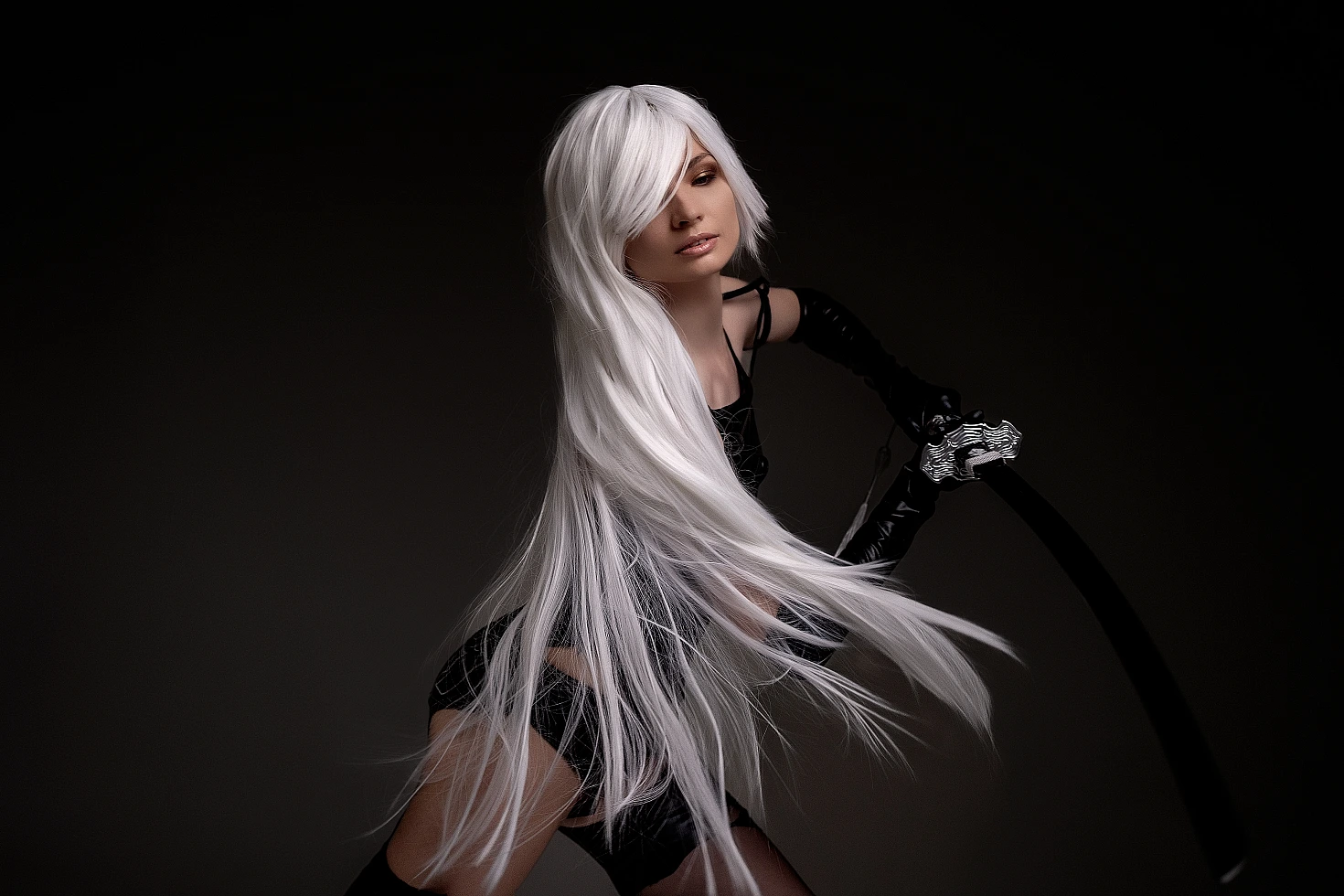 A2 cosplay NieR Automata close-up flowing white hair black strap details hand curved sword dramatic dark background