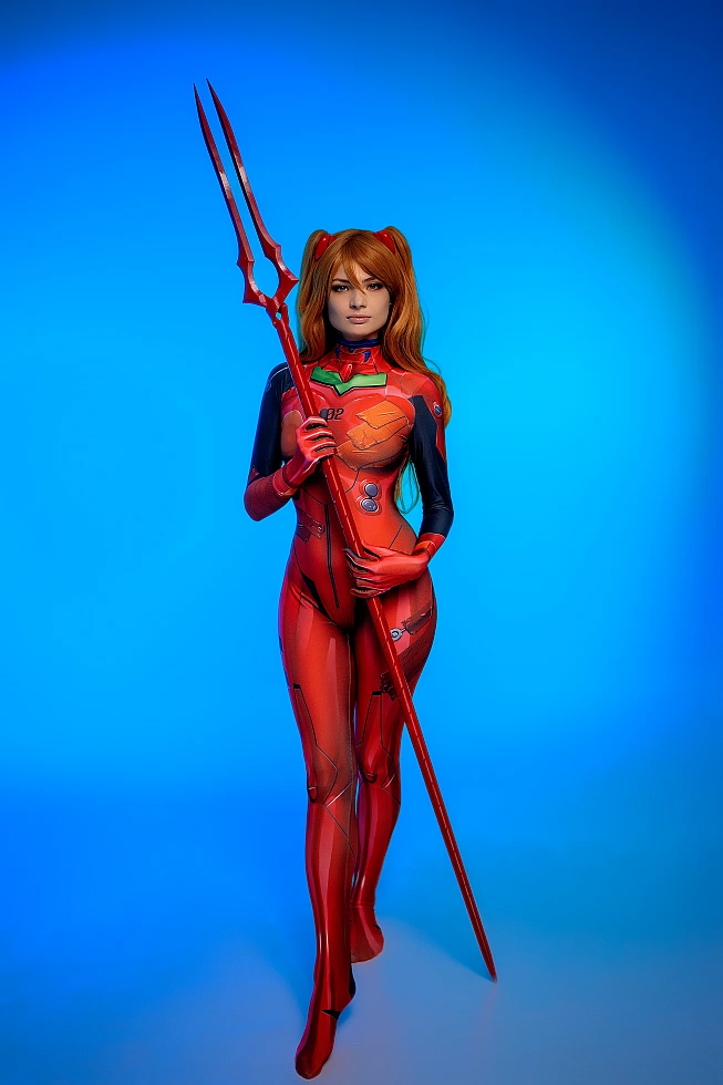 Asuka Langley cosplay holding trident in red plugsuit with neon studio lighting