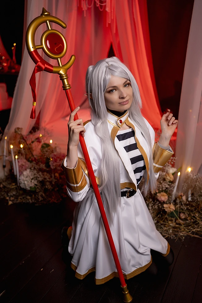 Frieren staff cosplay - elf mage holding magic staff with warm candlelight from anime Sousou no Frieren