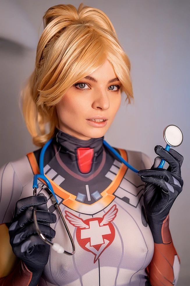 Mercy Angela Ziegler cosplay portrait with stethoscope and diagnostic mirror, medical bodysuit emblem, professional soft lighting
